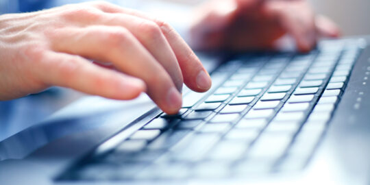 The hands of an SAP Specialist typing on a laptop keyboard