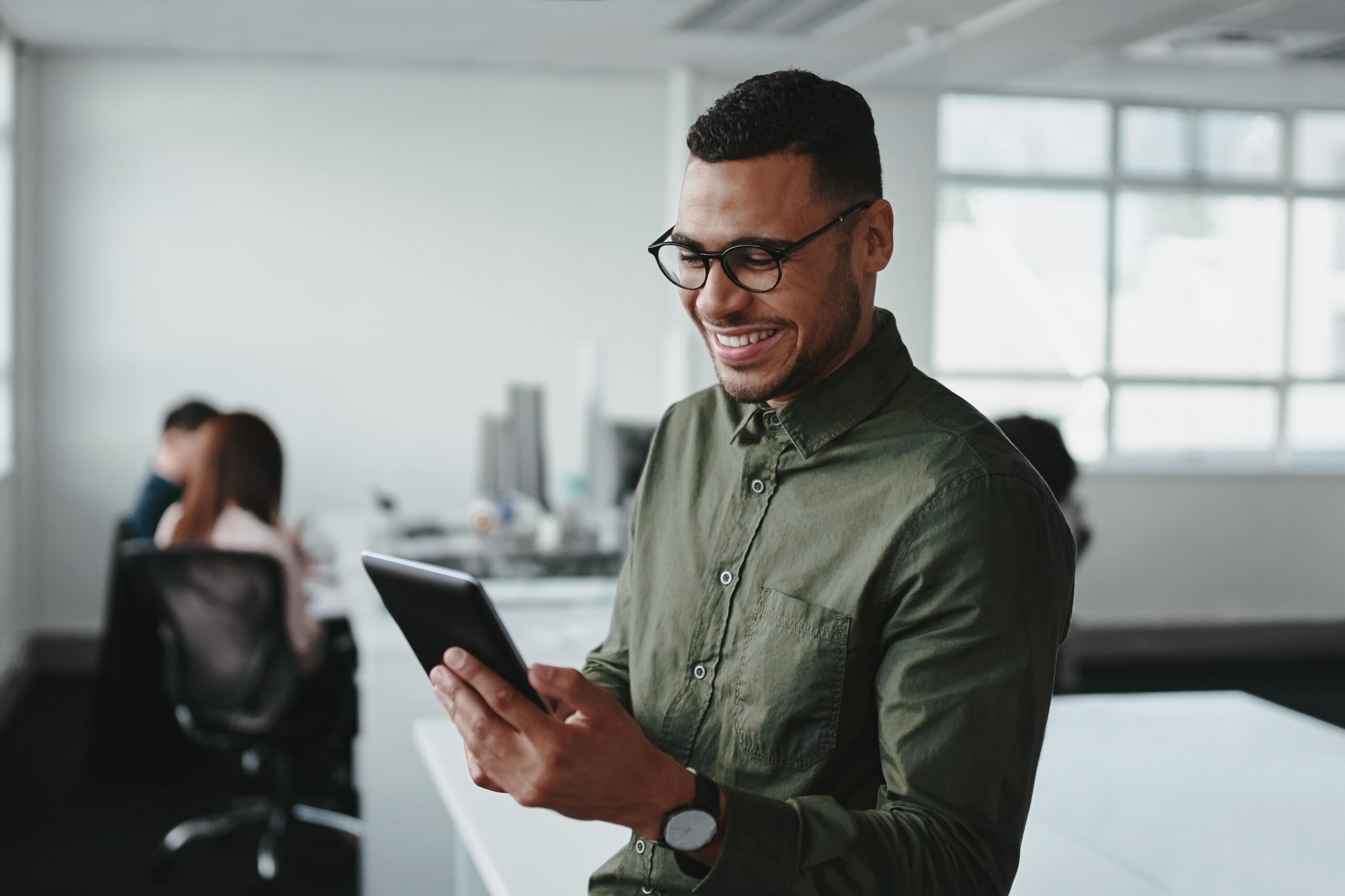 Smiling young SAP Specialist touching smartphone and checking online information in the modern office